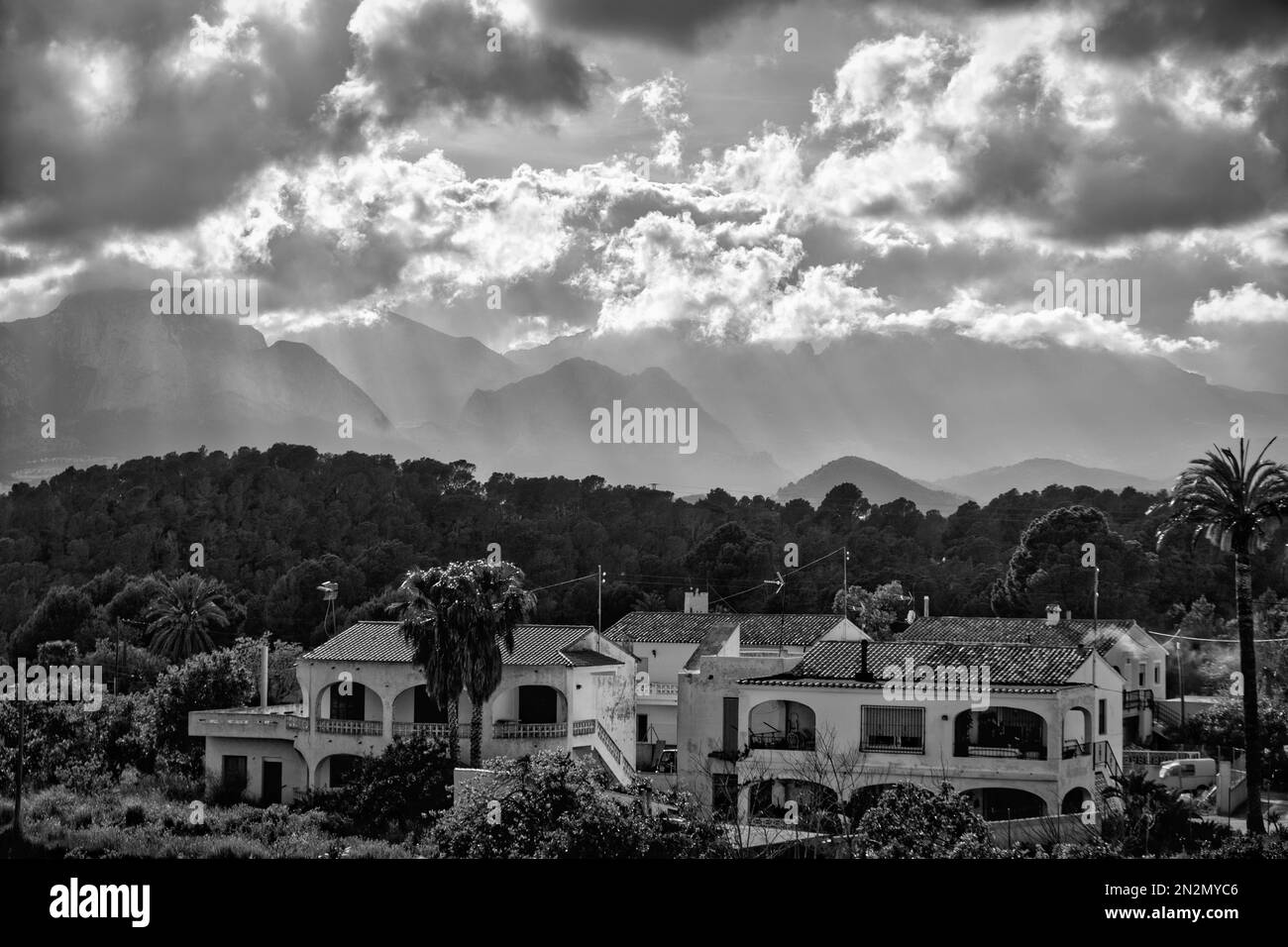 white walled mediterranean houses in lush green valley framed by rugged