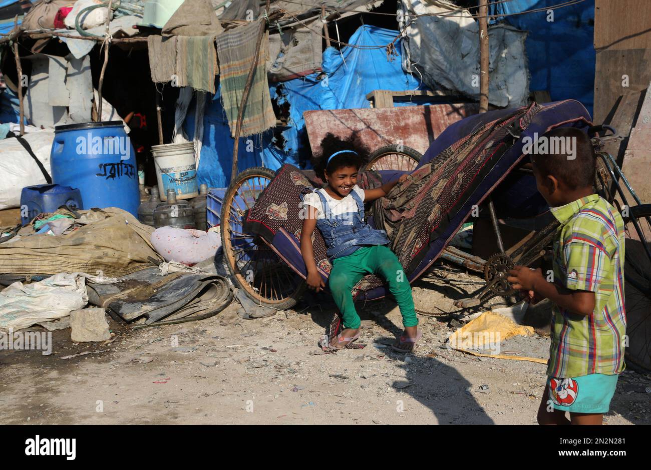 Children play outside their home at a slum in Bangalore, India