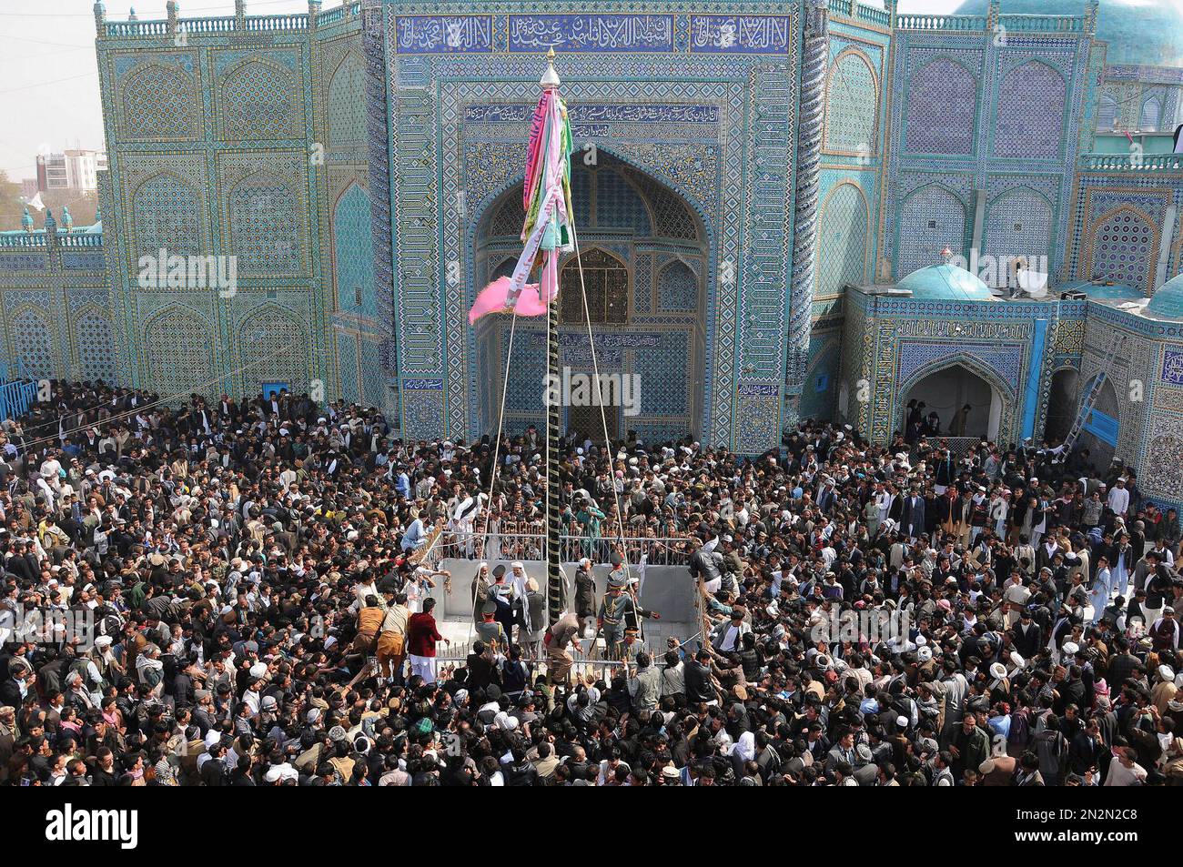 Afghan men raise the holy mace during celebrations of Nowruz, the