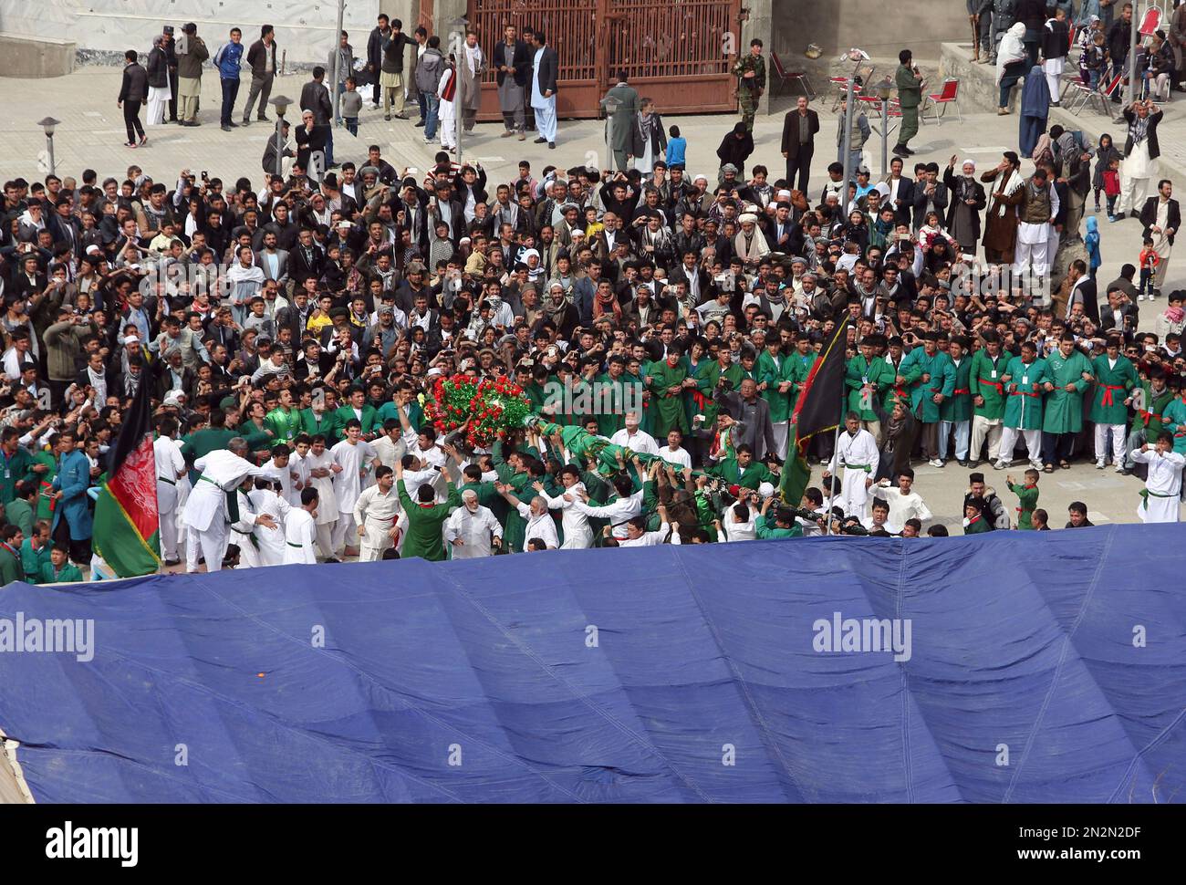 Afghan men raise the holy mace during celebrations of Nowruz, the