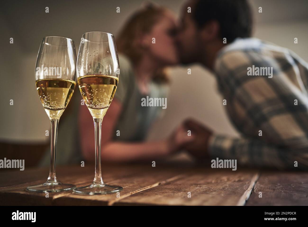 Champagne, glasses and love on valentines day with a couple kissing in
