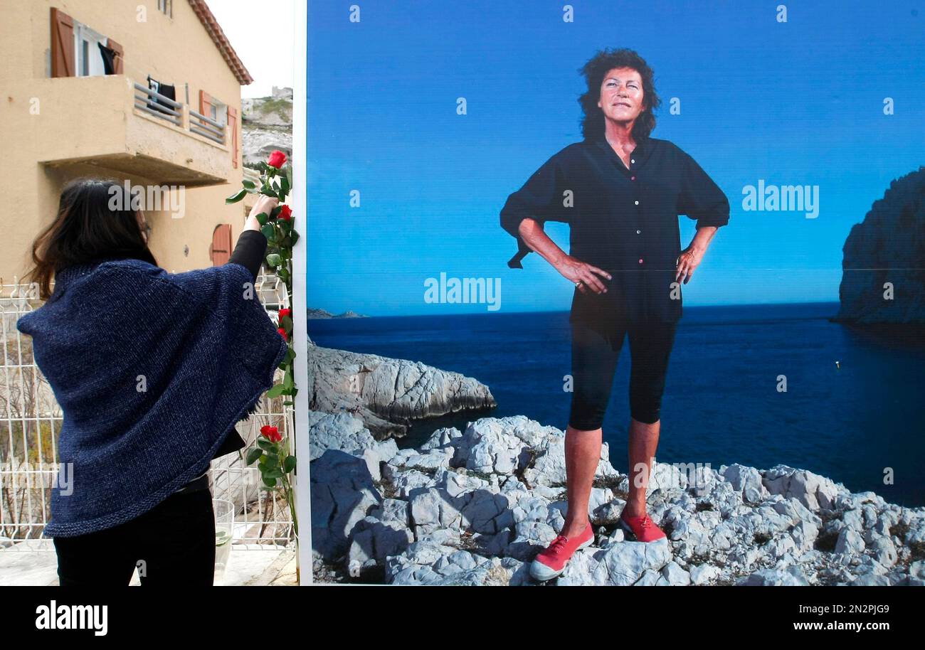 A woman places flowers in front