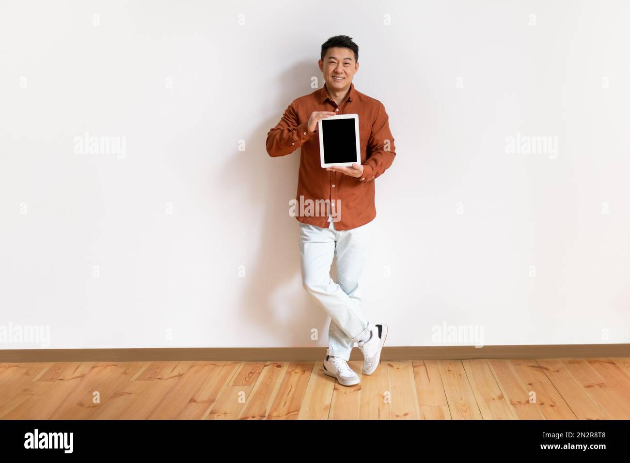 Happy middle aged asian man showing digital tablet with blank screen ...