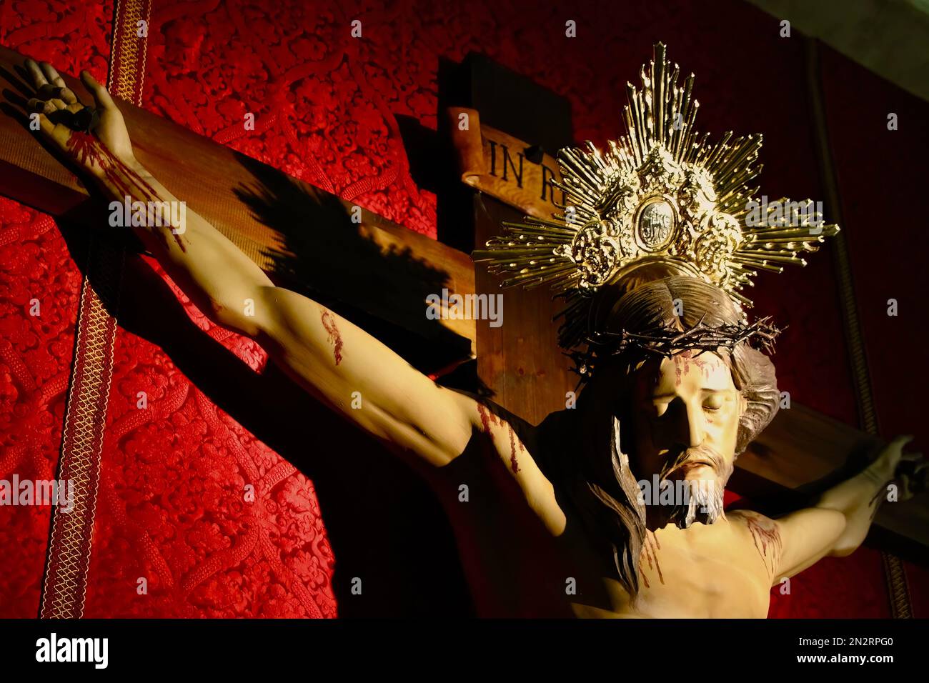 Close up of Christ on the cross artificially lit in the Saint Johns church Valencia Spain Stock Photo