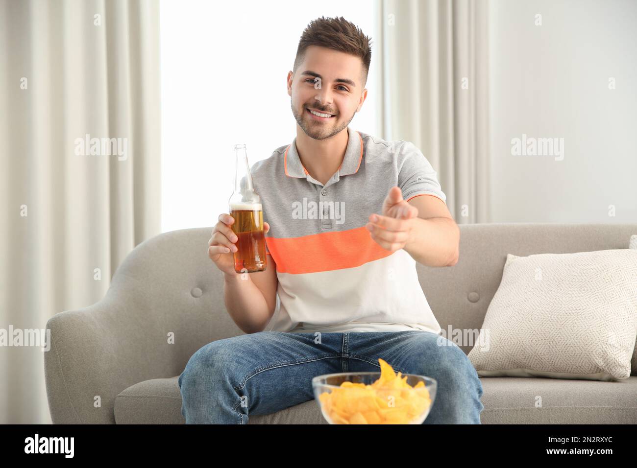 Man drinking beer while having online video conference at home, view
