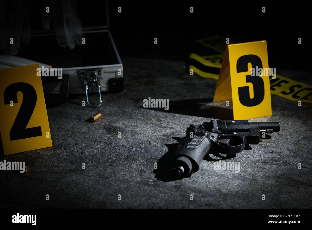 Shell casing, gun and crime scene marker on grey stone table Stock ...