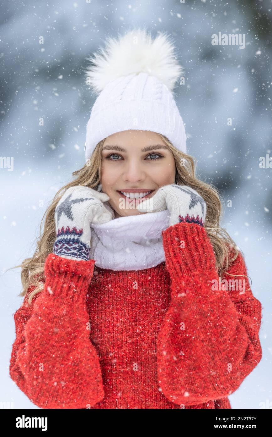 Joy and good mood of a young lady in a winter outfit in a snowy park. Stock Photo