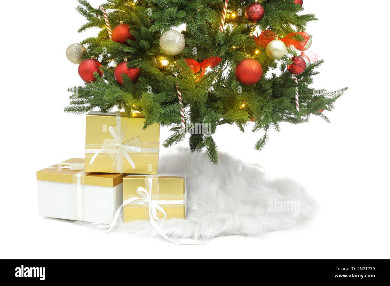 Beautiful decorated Christmas tree with skirt and gift boxes on white ...