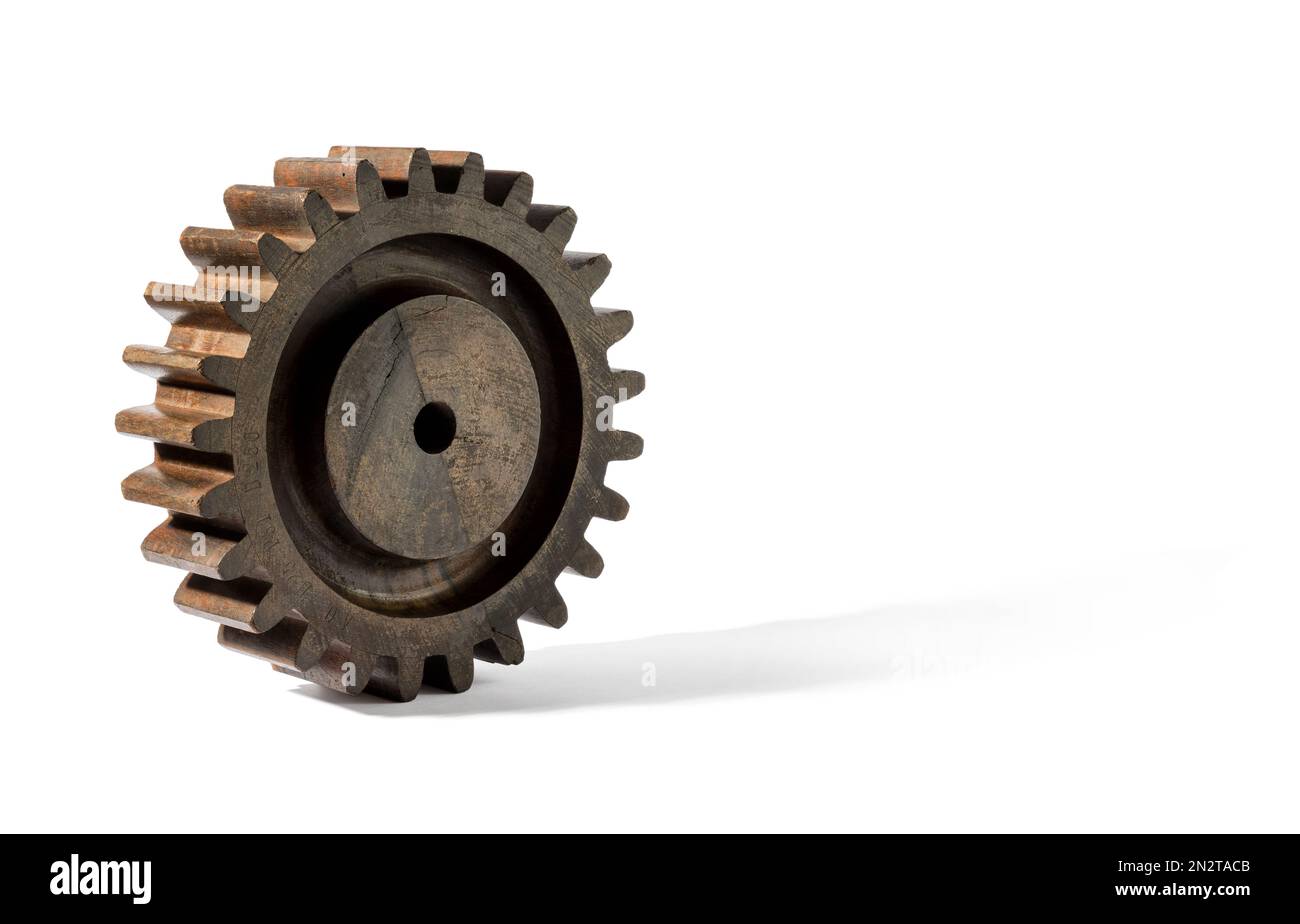 Brown vintage gear from old mechanism made of lumber rolling against while background Stock Photo