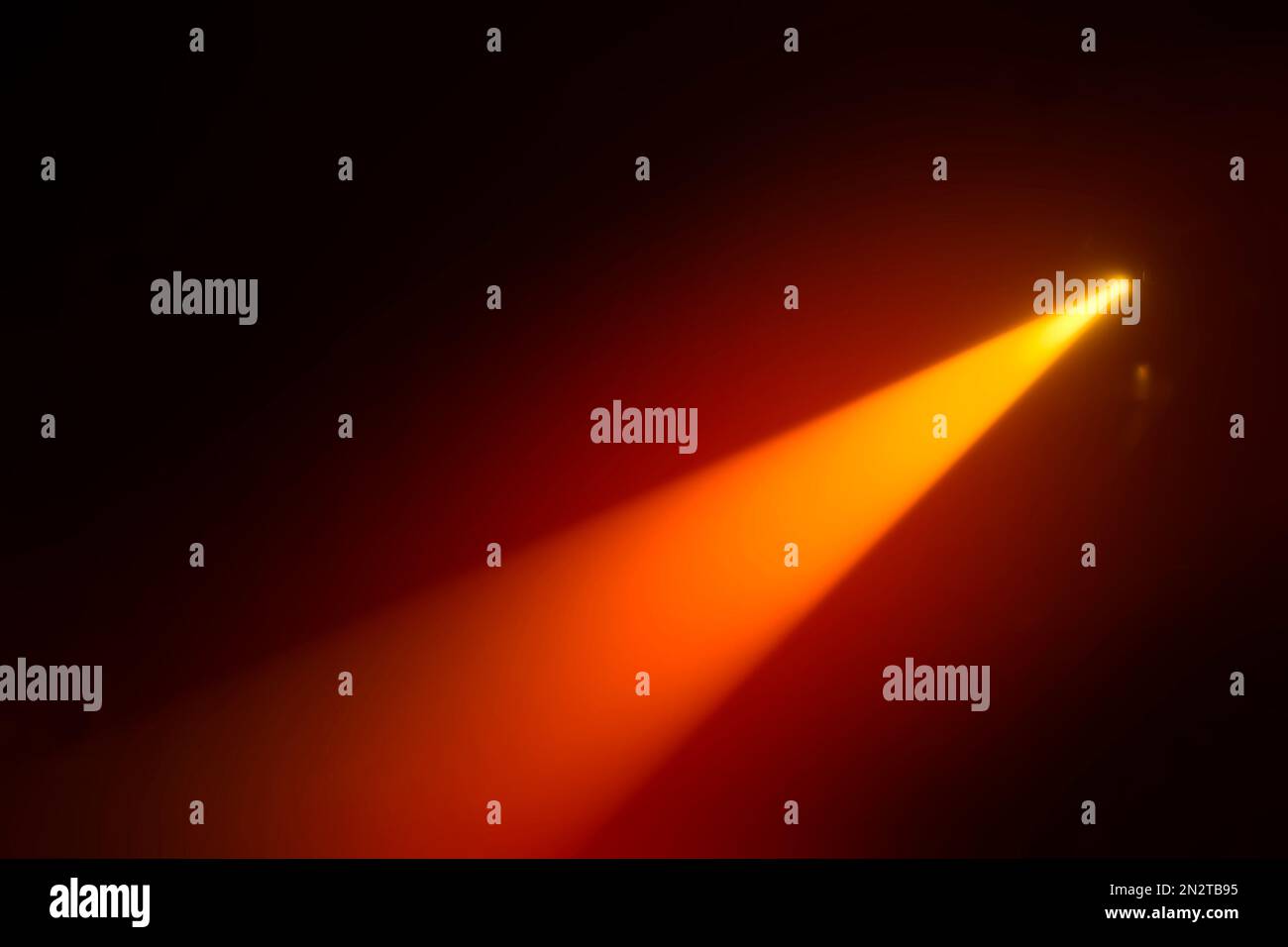 Orange blurred beam of stage light on a dark background Stock Photo - Alamy