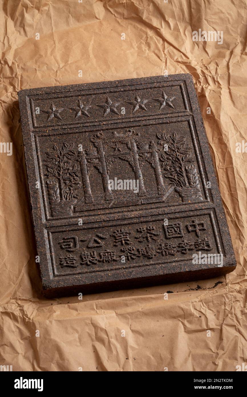 Unpacked Chinese tea brick from the Hubei Province close up on package paper as a present Stock Photo
