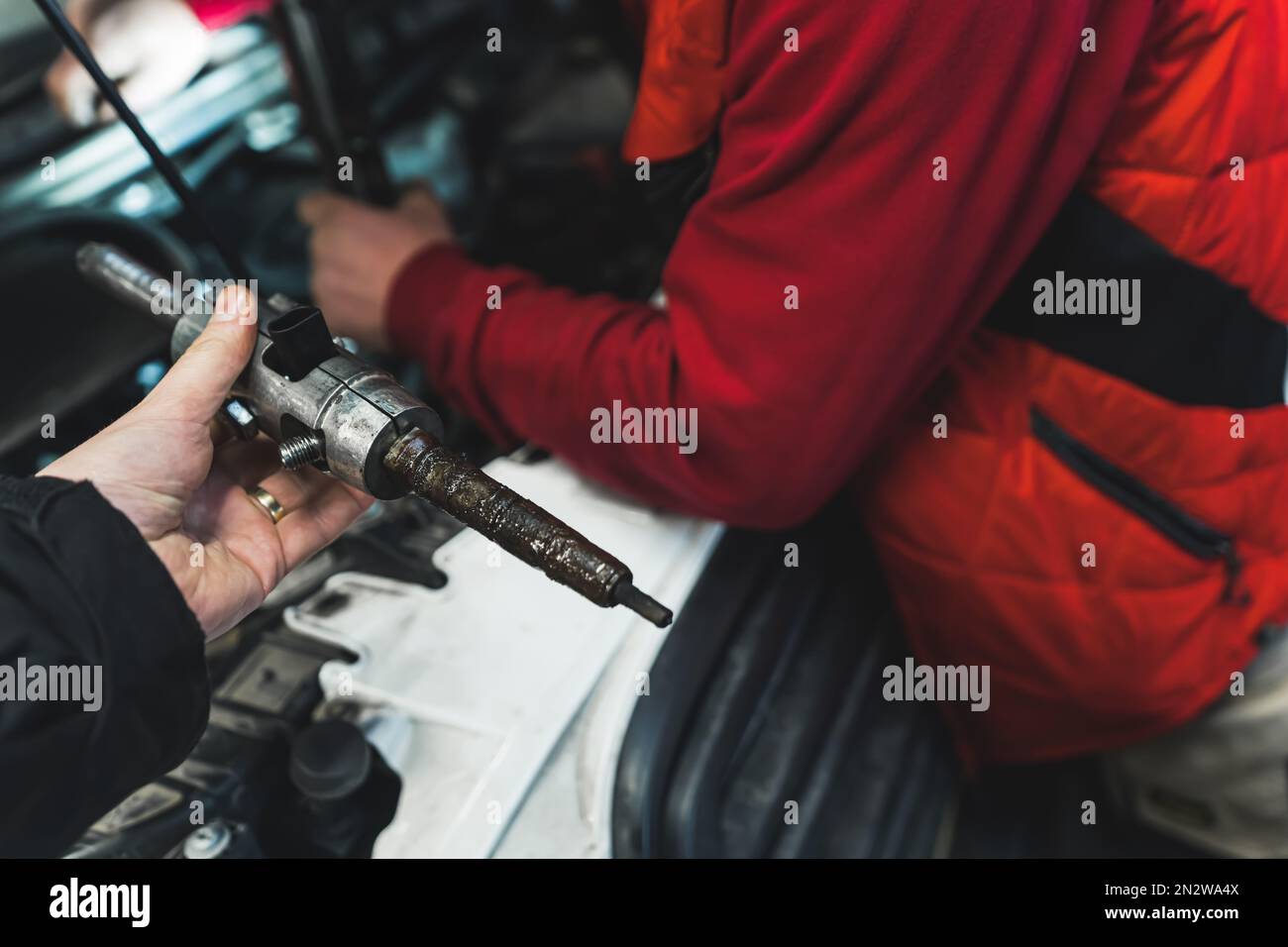 Removing stuck injector in diesel engine using press in an auto repair