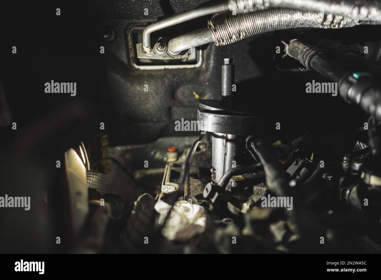 Removing stuck injector in diesel engine using press, closeup shot
