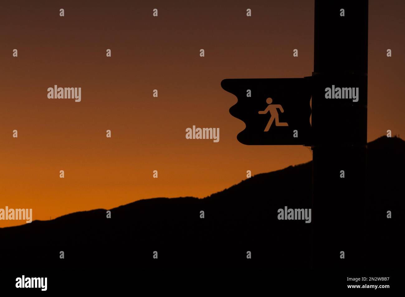 A sign showing a running path in silhouette against a spectacular ...