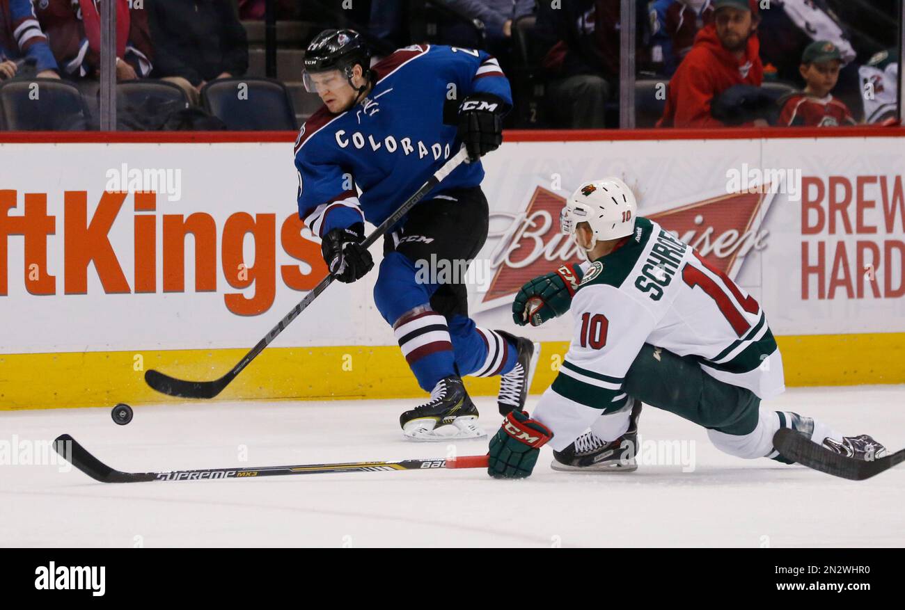 Colorado Avalanche center Nathan MacKinnon, back, uncorks a shot past