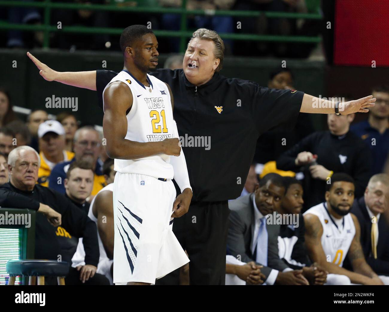 West Virginia head coach Bob Huggins, right, talks with forward