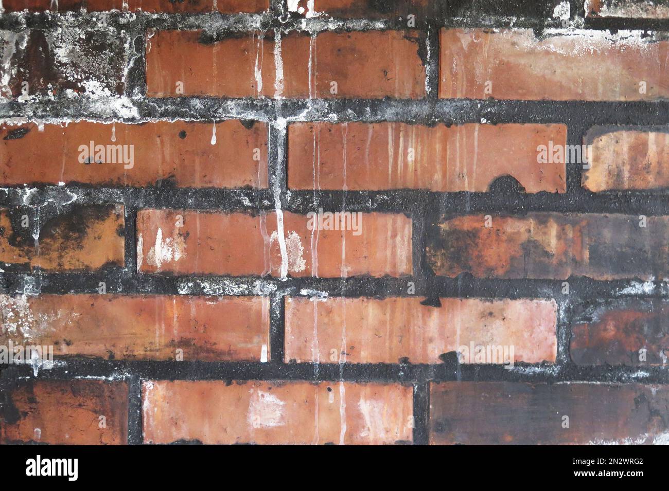 Dirty red brick texture with stains and white drips Stock Photo