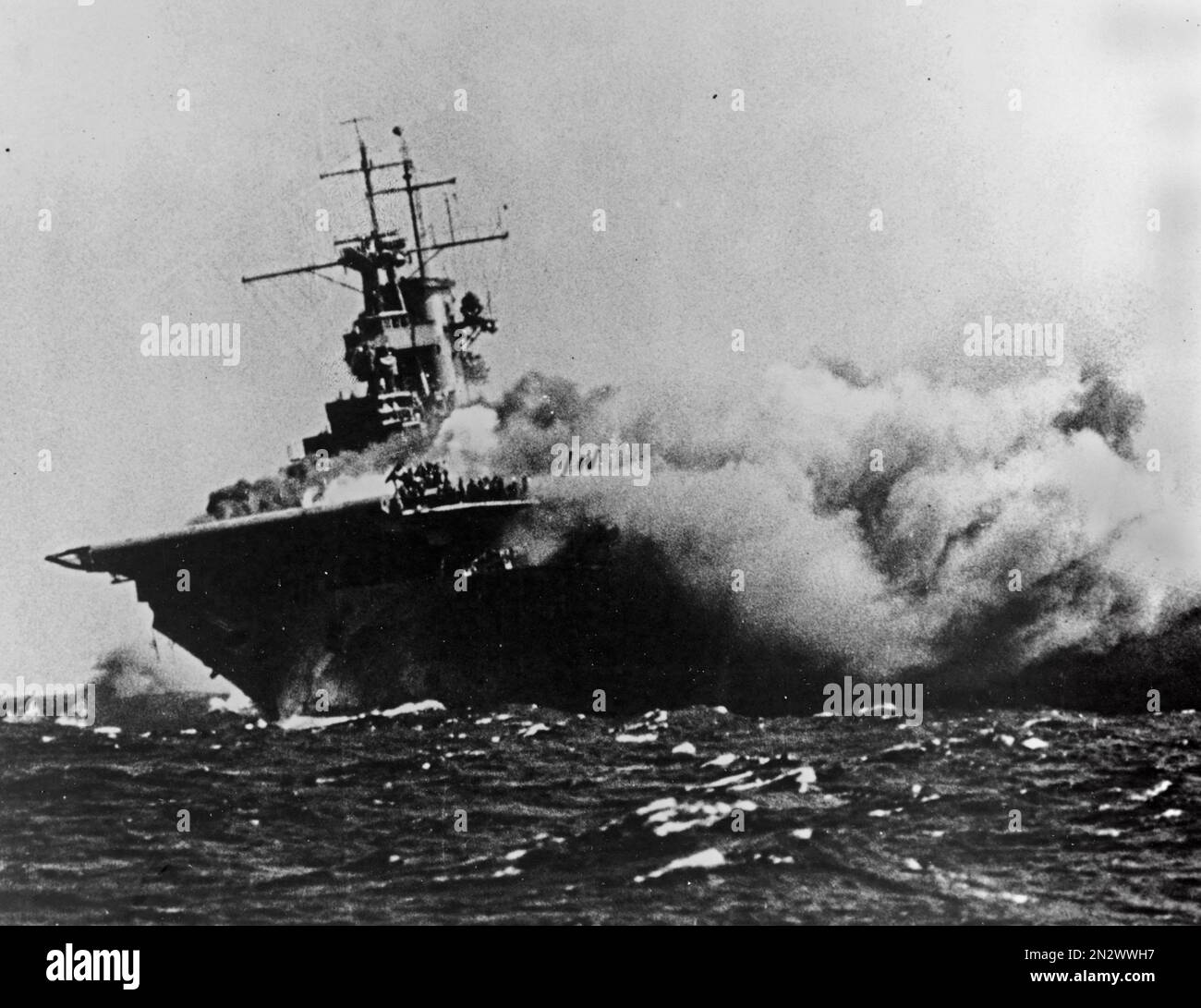 GUADALCANAL, SOLOMON ISLANDS - 15 September 1942 - The USS Wasp ( CV-7 ) burning and listing after she was torpedoed by the Japanese submarine I-19, o Stock Photo