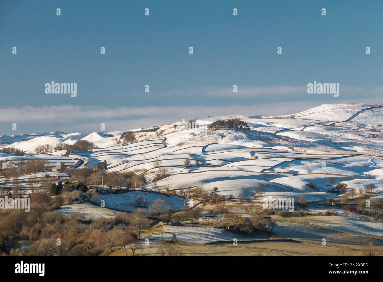 Teesdale's iconic landmark of Kirkcarrion stands out on the snow covered hillside in strong winter sunshine. Stock Photo