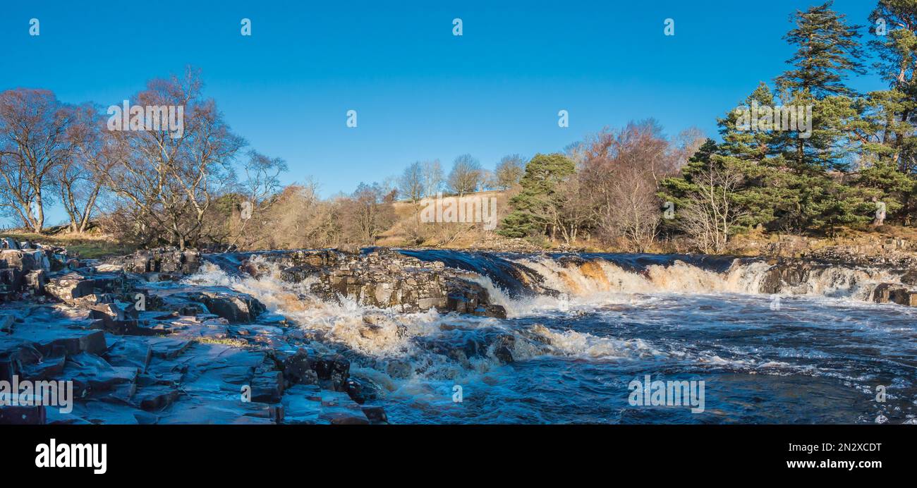 The horseshoe shaped cascade just above the main Low Force waterfall in very strong winter sunshine under a cloudless blue sky. Stock Photo