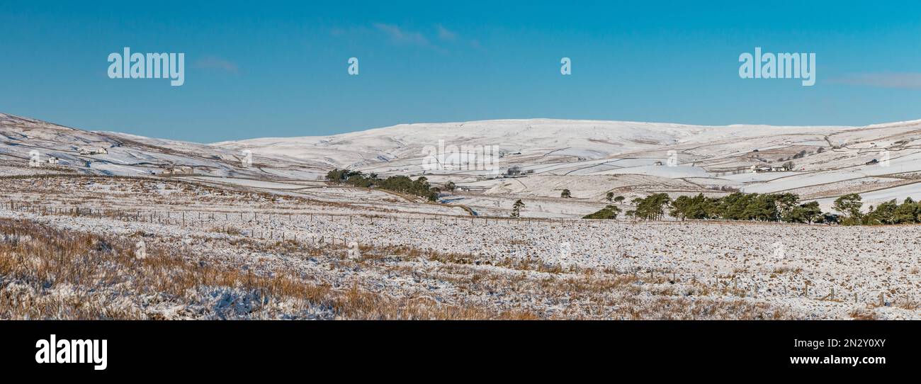 A panoramic view into a snow covered Harwood from the Cow Green access road under a cloudless deep blue sky Stock Photo