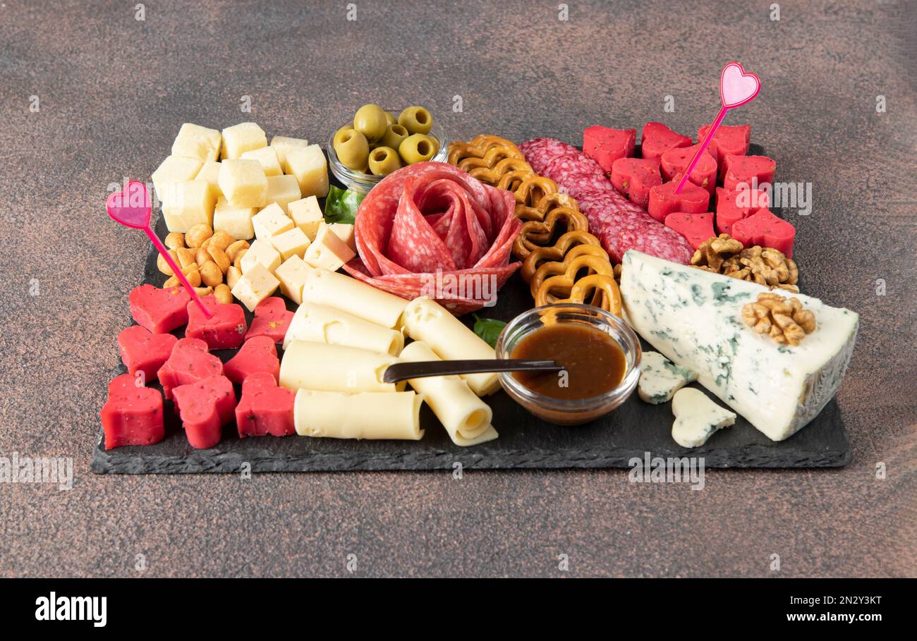 Charcuterie board for Valentines Day with varieties sausage, cheese