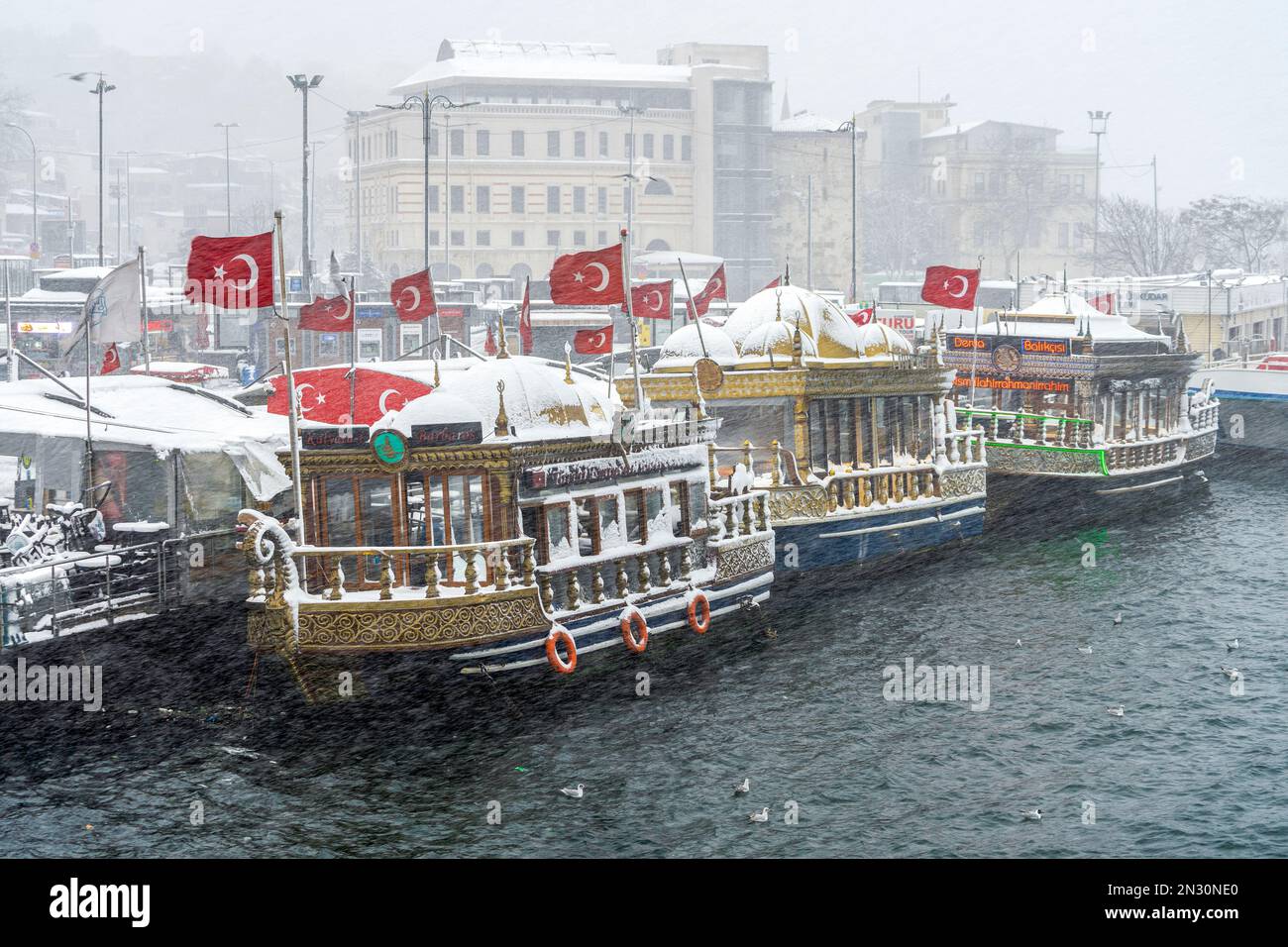 Snow-covered fish restaurants on boats on a winter day in Istanbul, Turkey. Stock Photo