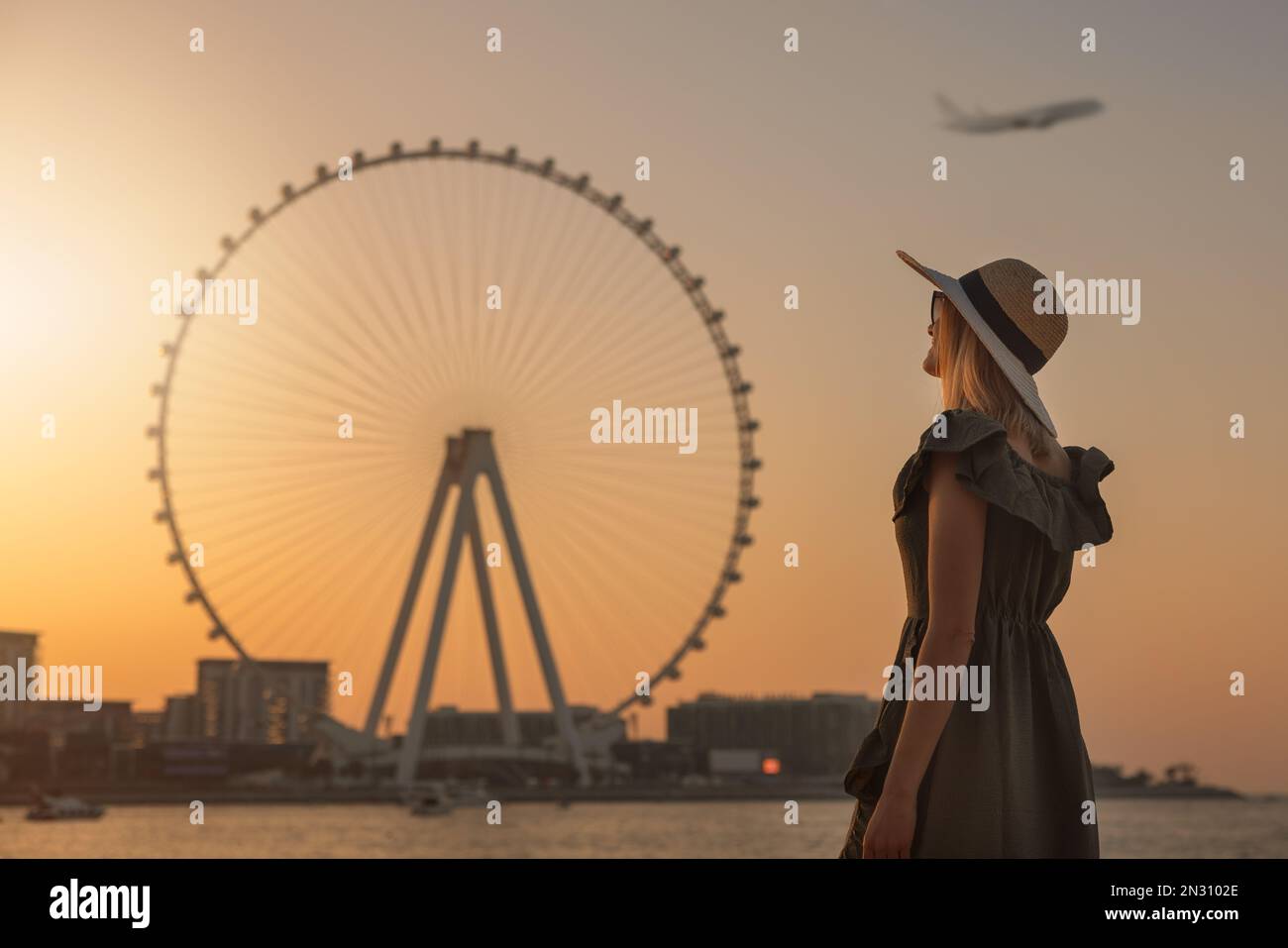 woman enjoying sunset and view to the ferris wheel Ain Dubai. UAE Stock Photo