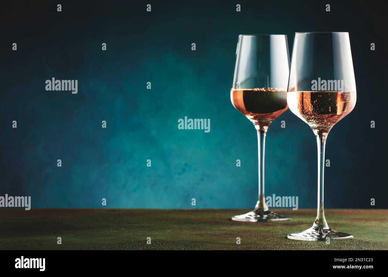 Rose pink wine with jalapeno pepper in wine glass, dark background