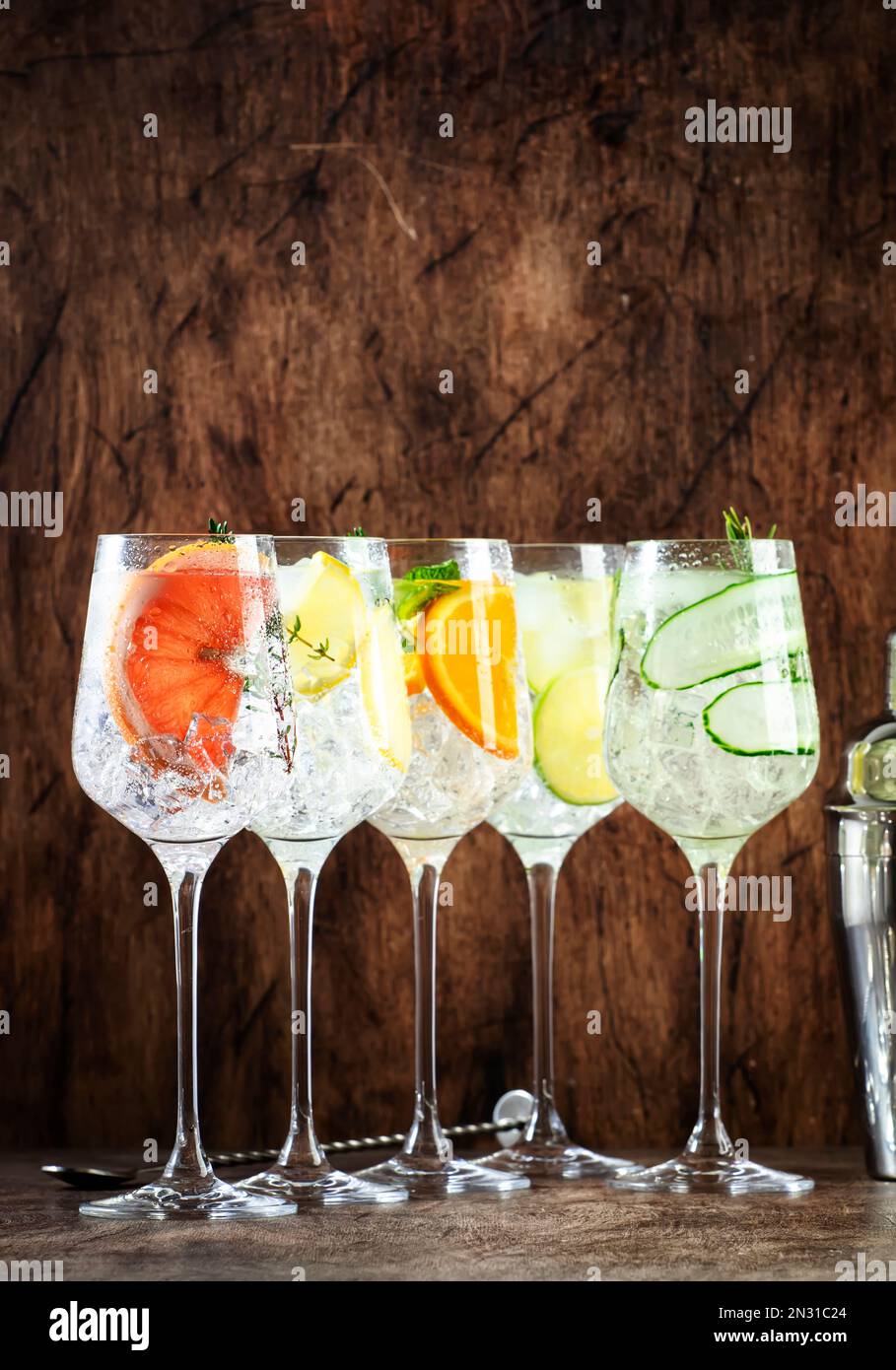 Two tall cocktail glasses with pink gin and tonic garnished with large  crystals of salt on an edge of a glass, large piece of ice, peppermint  Stock Photo - Alamy