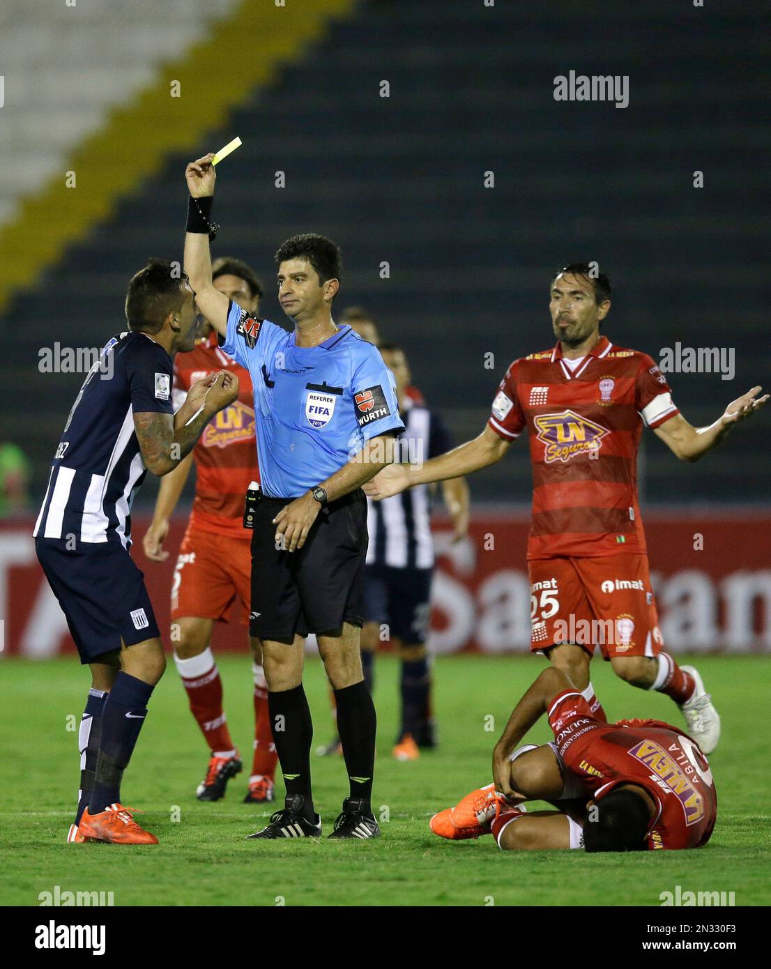 Colombian referee Jose Buitrago shows the yellow card to Pablo Miguez 