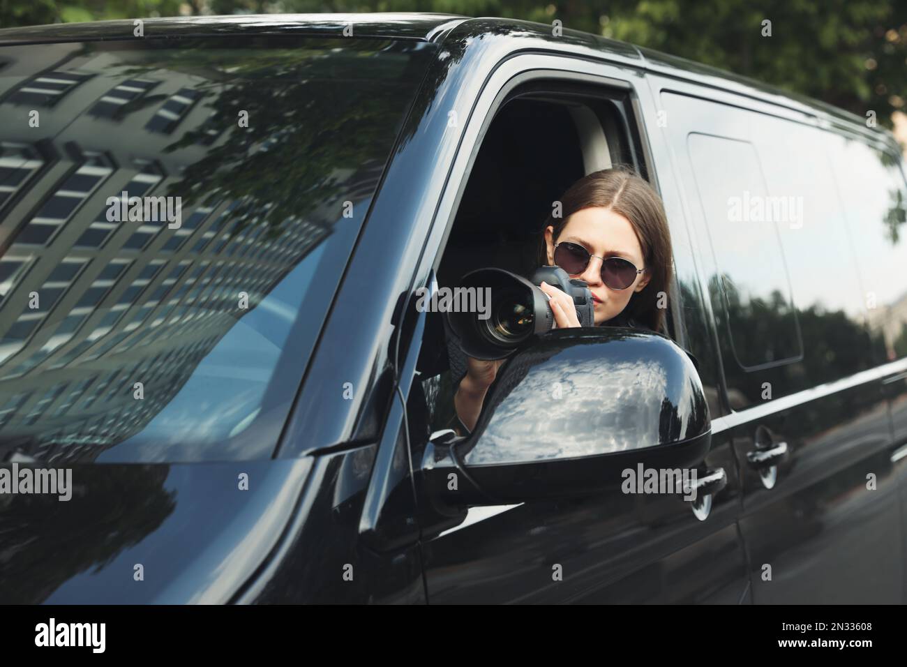 Private detective with camera spying from car Stock Photo