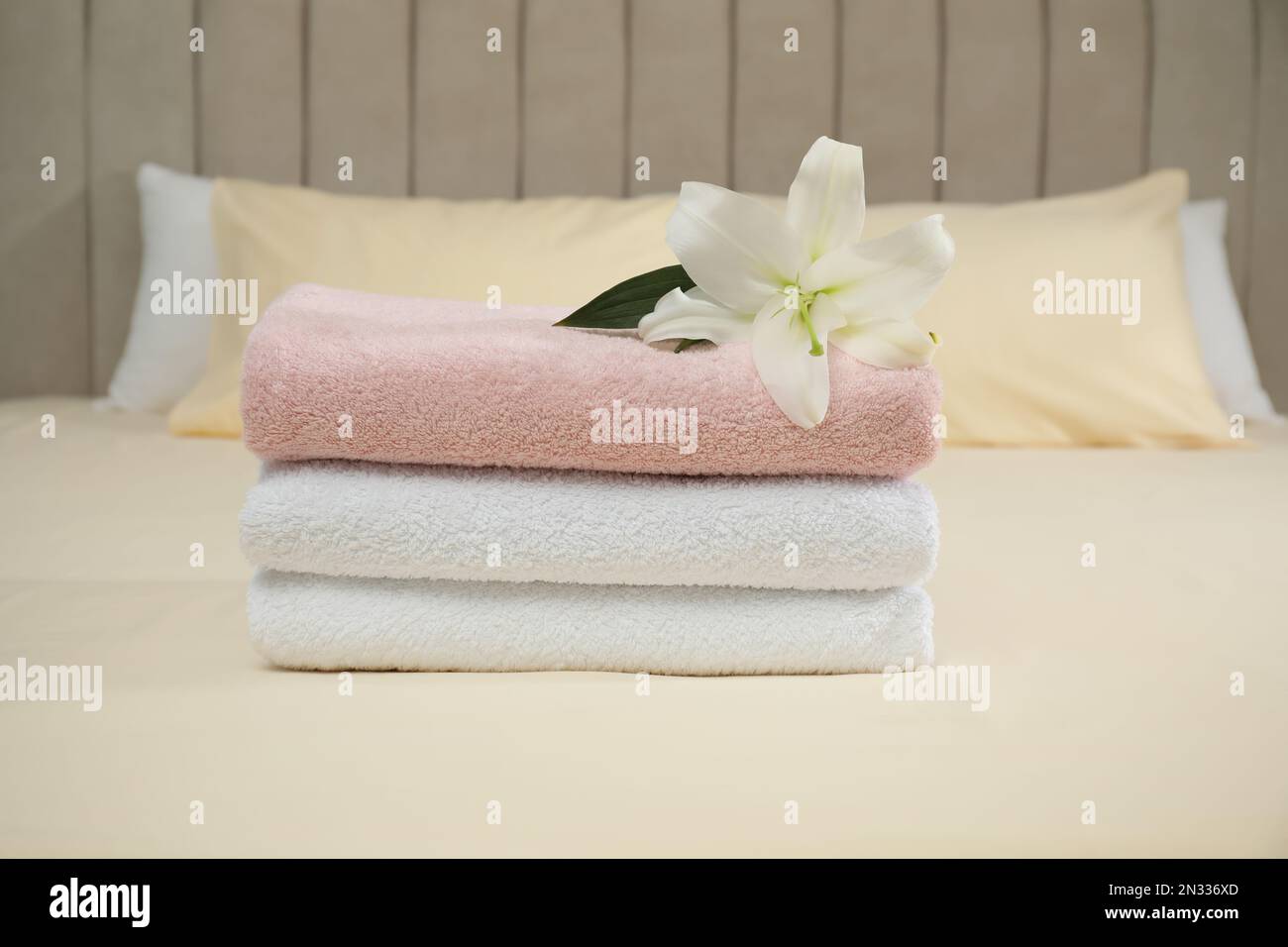 Stack of clean fluffy white towels on the bed Stock Photo - Alamy