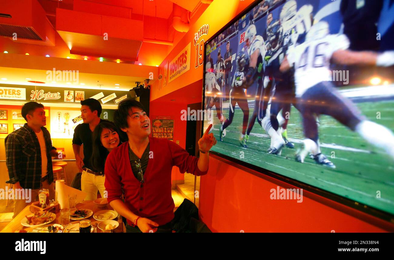 Japanese watch the replay of Super Bowl game played earlier in the day