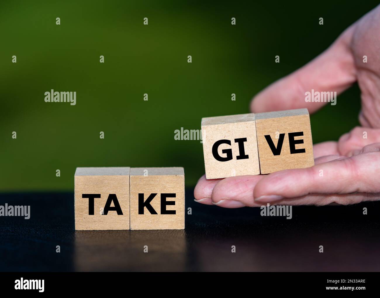 Cubes form the words give and take. Symbol for giving instead of taking something. Stock Photo