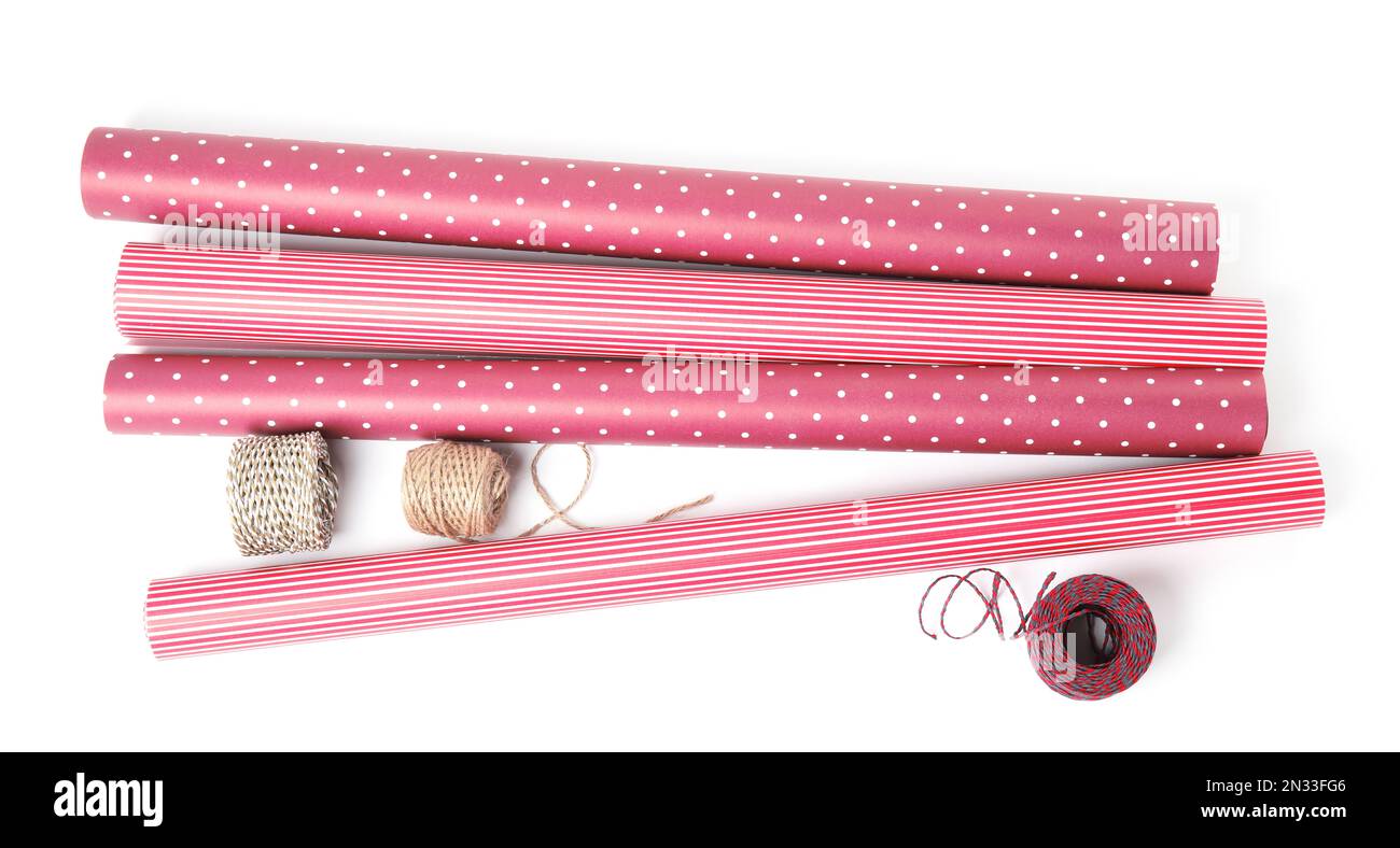 Different colorful wrapping paper rolls and ropes on white background ...