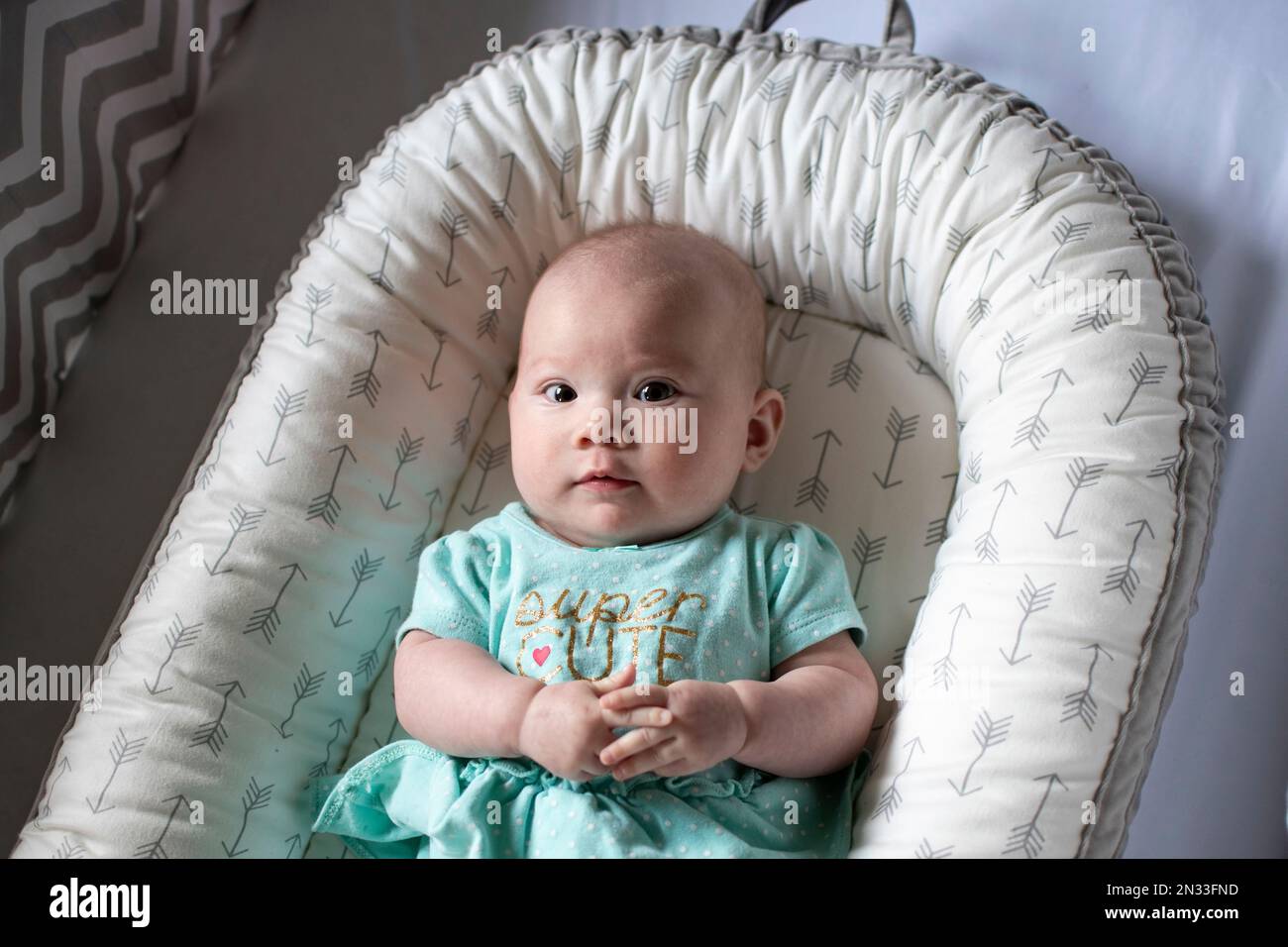 4 months old Caucasian cute baby girl in a crib. Infant girl. Newborn baby. Stock Photo