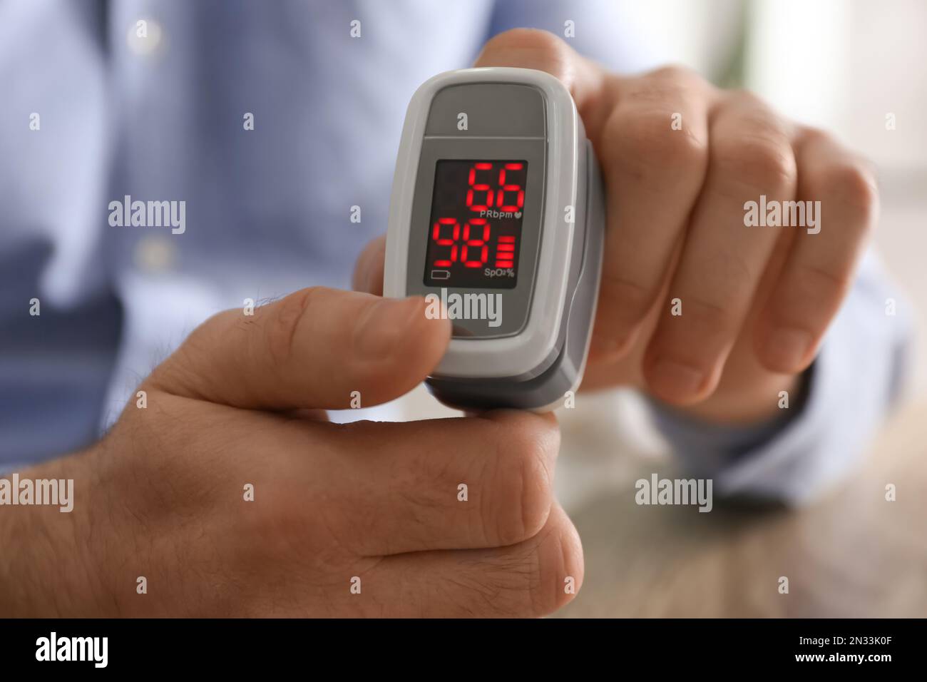 Man measuring oxygen level with modern fingertip pulse oximeter