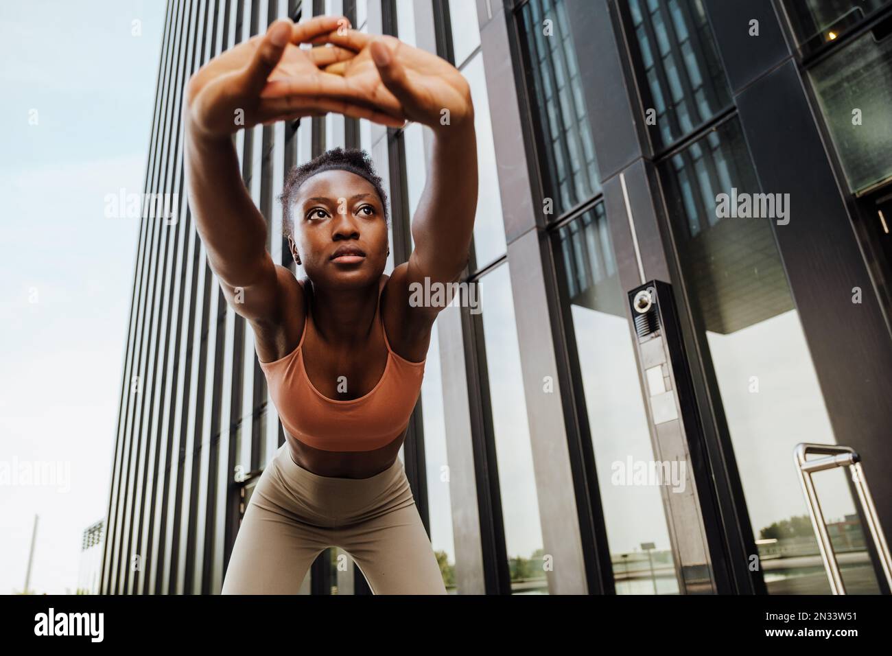 Young beautiful sporty calm african woman stretching her back bending