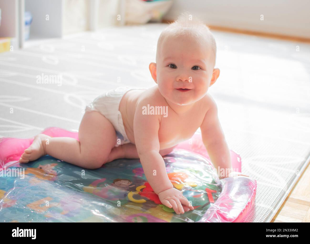 Cute little caucasian baby girl learning how to crawl Stock Photo