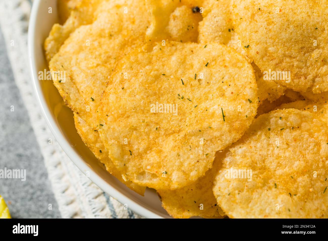 Homemade Flavored Dill Pickle Potato Chips in a Bowl to Eat Stock Photo