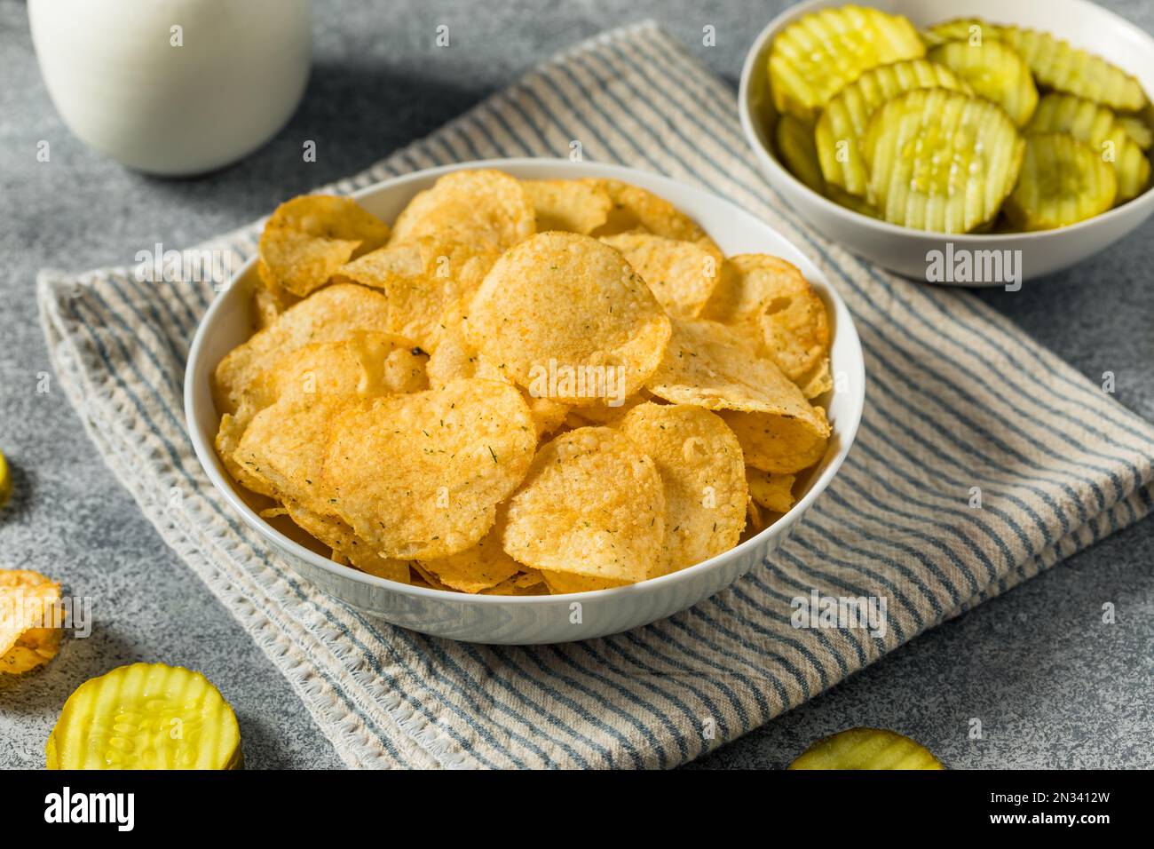 Homemade Flavored Dill Pickle Potato Chips in a Bowl to Eat Stock Photo