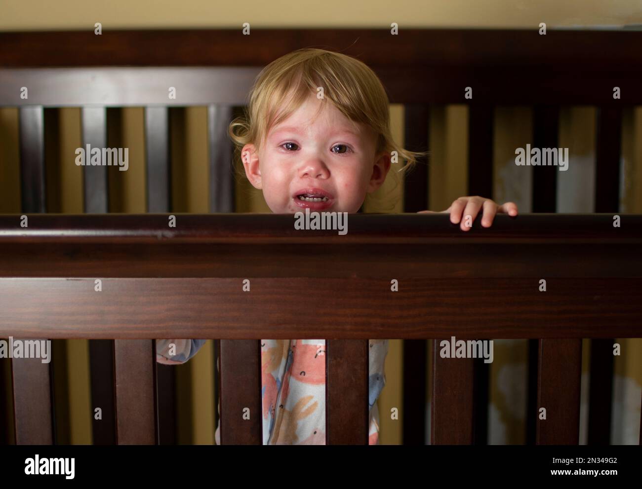 Caucasian baby girl crying in the crib. Sad Sick child Stock Photo Alamy