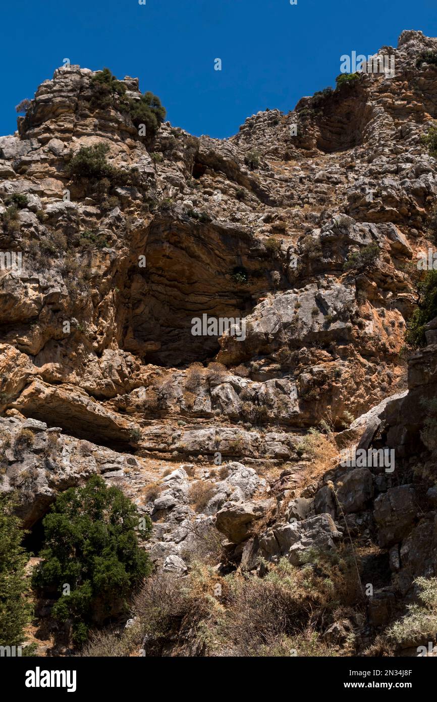 Cave on steep slope of a mountains at Rhodes Island Stock Photo