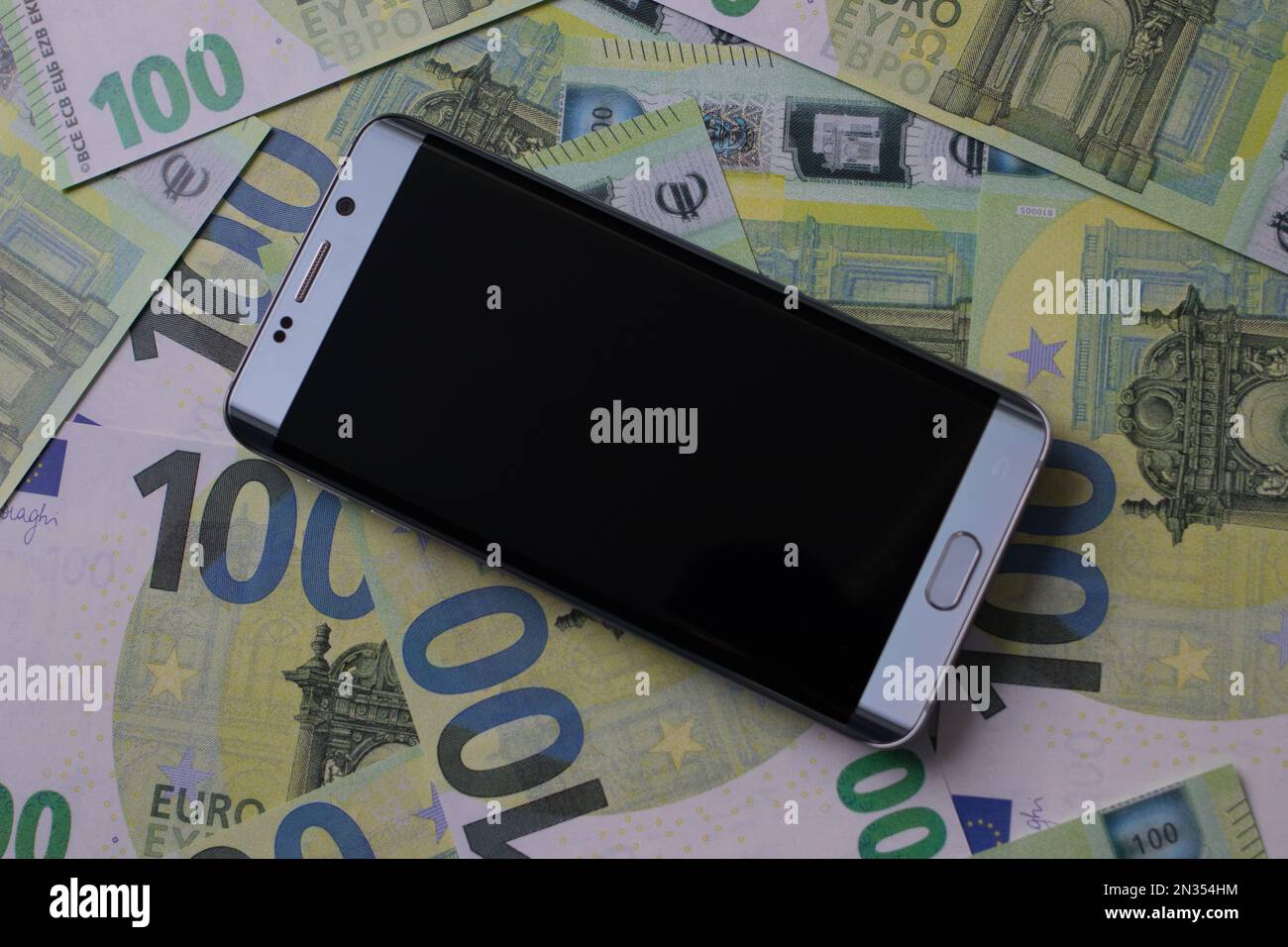 smartphone lies on 100 euro banknotes Stock Photo