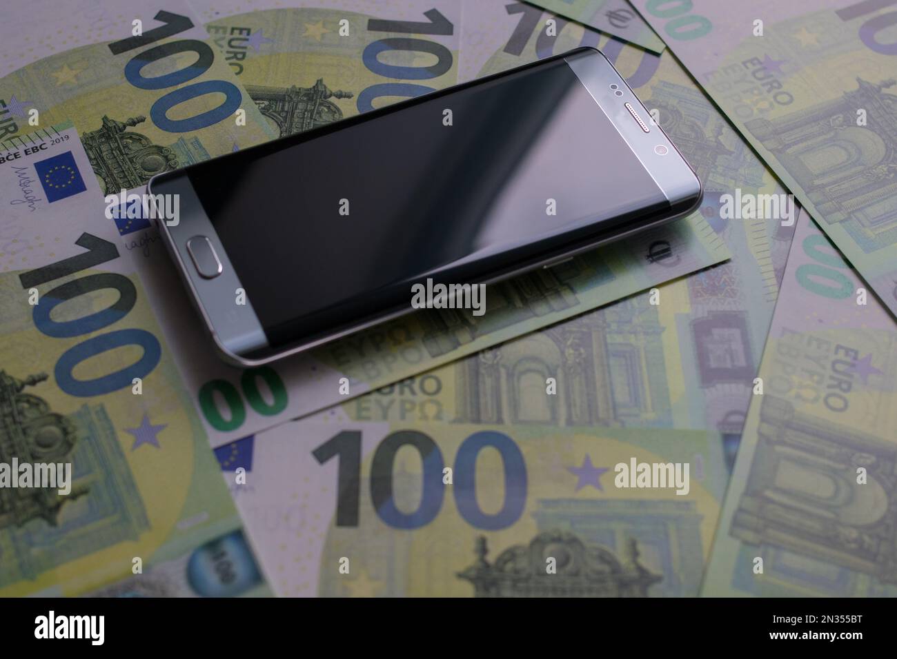 smartphone lies on 100 euro banknotes Stock Photo
