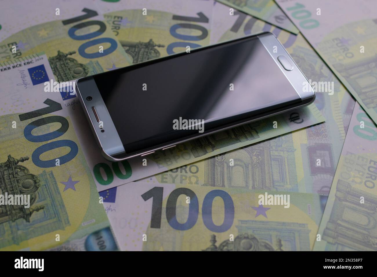 smartphone lies on 100 euro banknotes Stock Photo