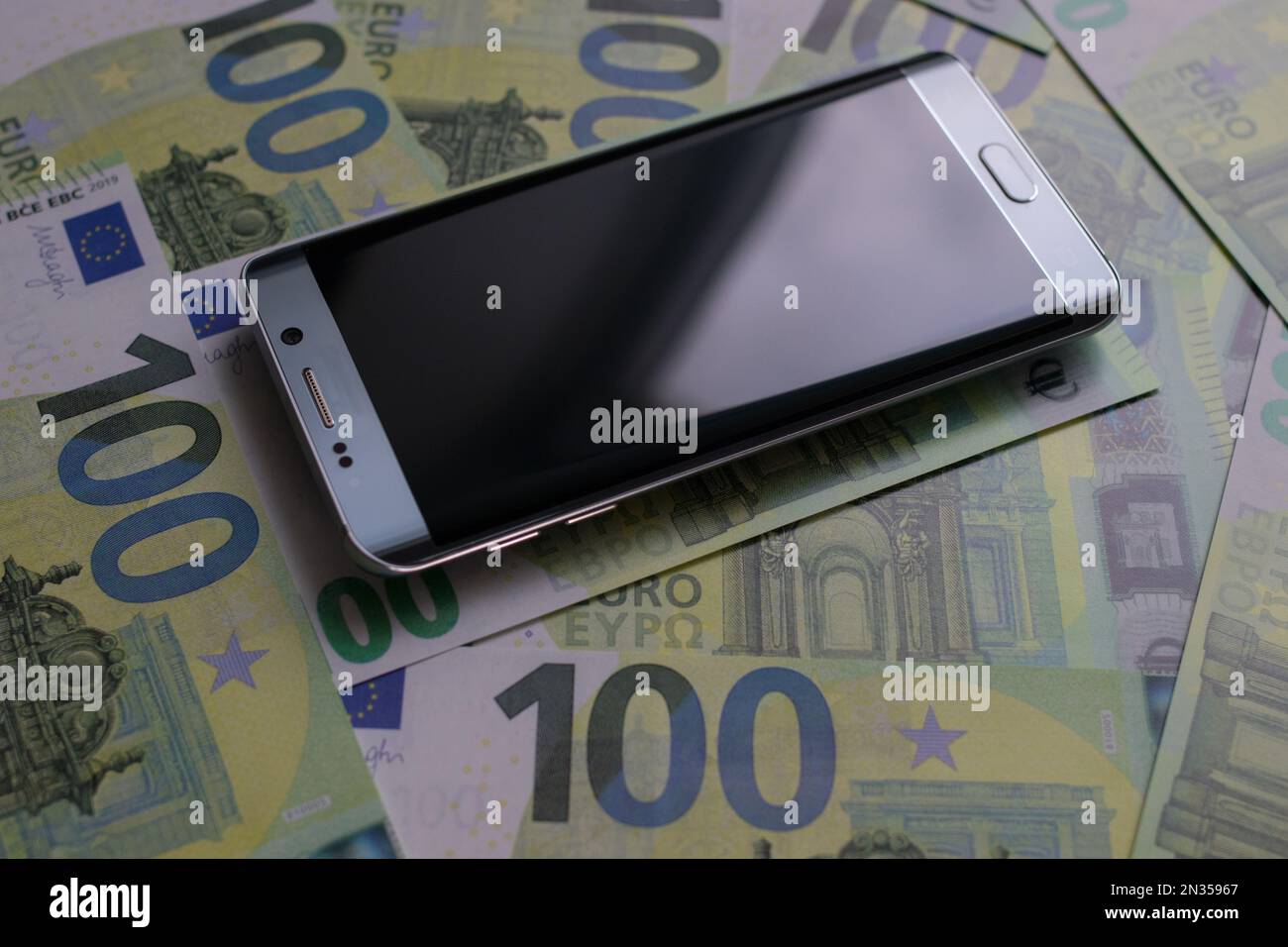 smartphone lies on 100 euro banknotes Stock Photo