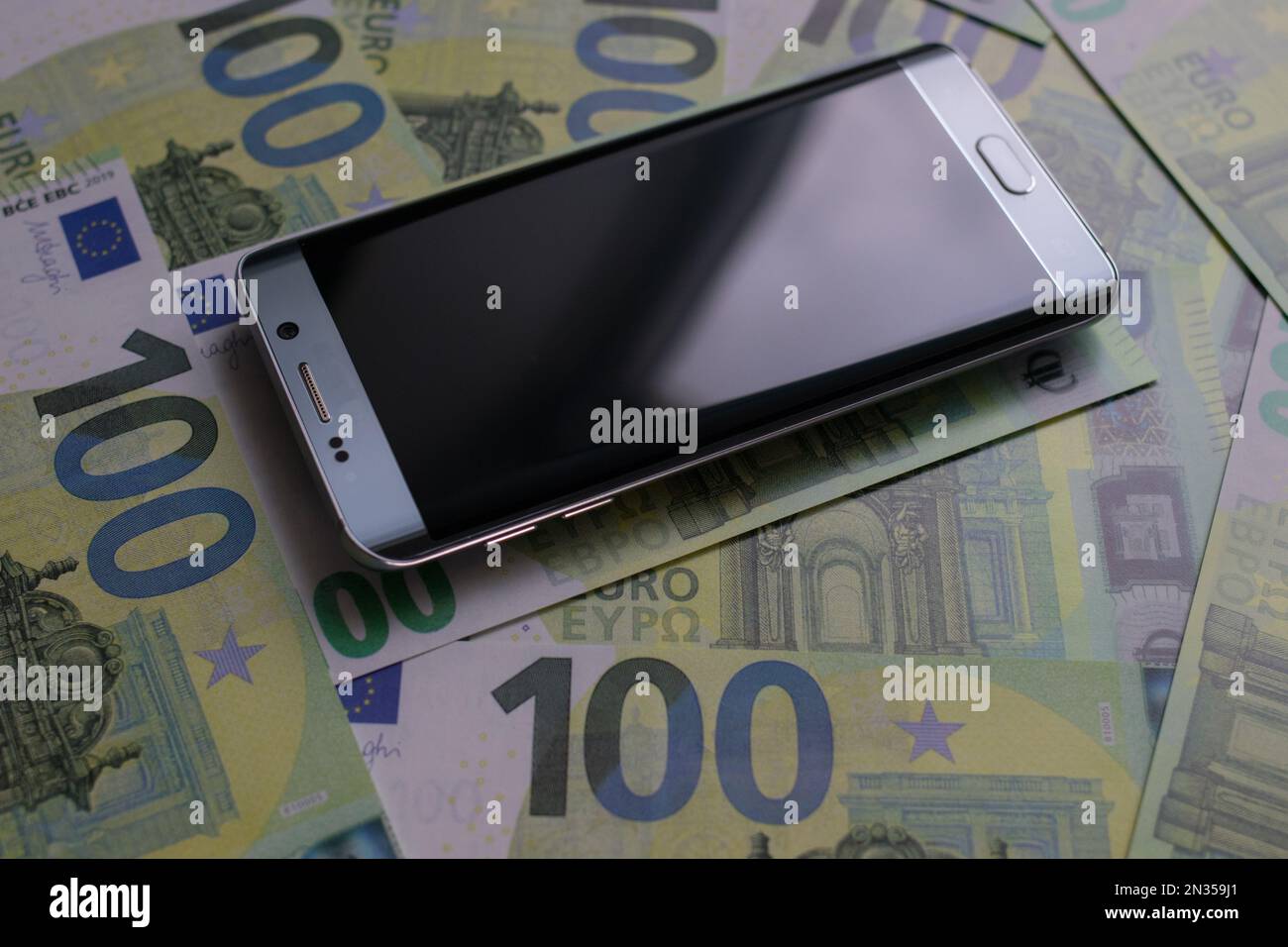 smartphone lies on 100 euro banknotes Stock Photo