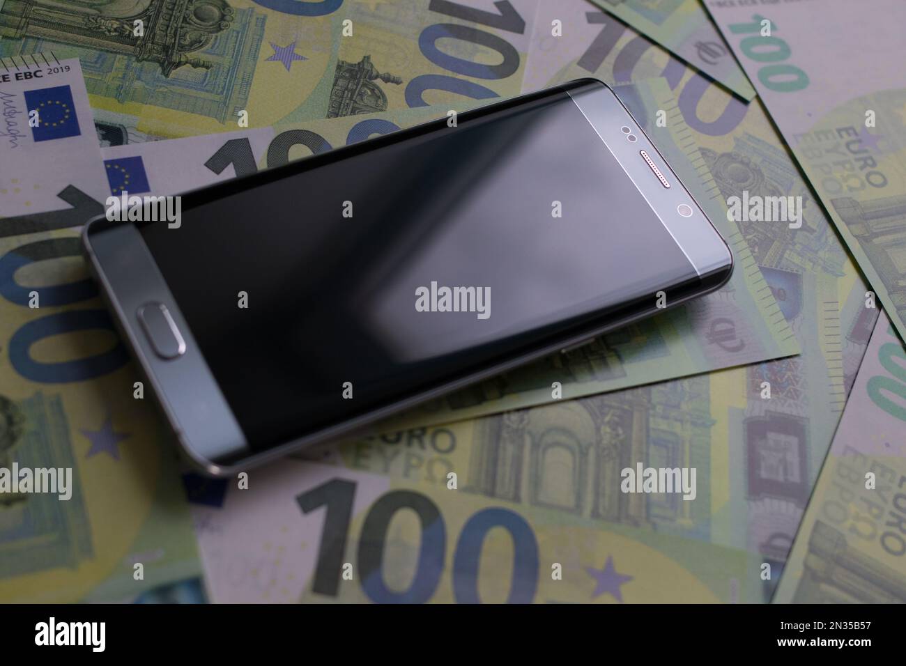 smartphone lies on 100 euro banknotes Stock Photo